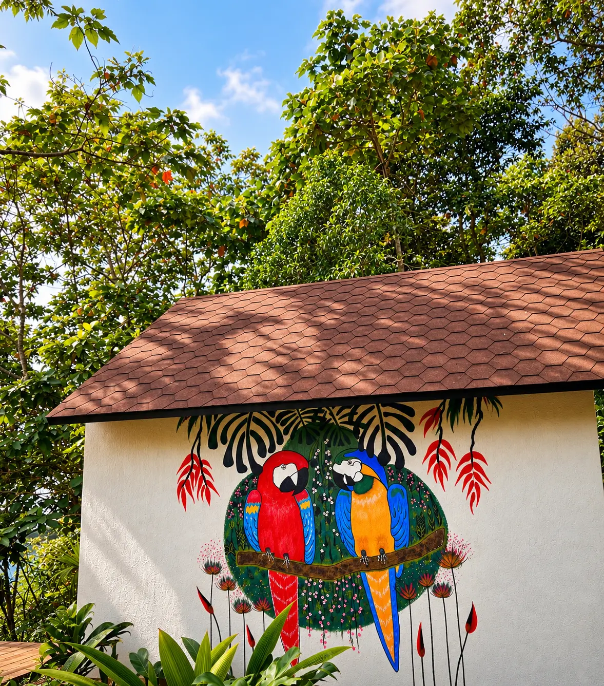 Mural de dos guacamayos en la pared exterior de Diwalli entre el bosque